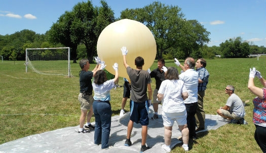 A group of teachers holding a large balloon up together outside froma Teachers Institute session in Dayton Ohio.