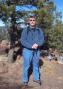 Bob K0NR standing near the summit of Mt Herman with all the VHF radio gear in a backpack.