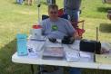Scott KC0BHE appears to staff the information booth. In reality, just taking advantage of the shade.