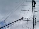 Carcia and Strelow, working as ground crew, guide the 40 meter beam up the tower. [S. Khrystyne Keane, K1SFA, Photo]