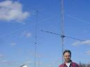 Duffy stands in front of his 15 meter tower that tops 120 feet. Behind him to the left is the 190 feet tall tower that, back when this picture was taken in 2000, held three stacked Yagis for 40 meters, as well as a 10 meter antenna. [Ward Silver, N0AX, Photo]