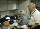 A veteran of 30 years coping with Gulf hurricanes, Dave Martin K5YFO/AAA6TX (standing), put his experience to work helping compile the
MARS 101
training cycle. Martin is Texas State Director of Army MARS and is shown here at the MARS position aboard a mobile command post. [MARS photo]