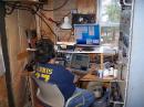 Dennis, W1UE glued to the chair and beating up on the bottom end of 28 MHz. Dennis loves CW and can copy stuff that I don't even pick up. The gear on the right in the rack is all VHF amplifier stuff. The 10 M amp is not visible here. Someday I have promised to update the decor in the shack. The building is 2000 ft from the house up on a ridge line in the Maine woods. The mice love it too.