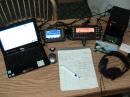 Photo of the KP4MD/P portable "station in a suitcase" consisting of an Elecraft KX3 with the PX3 panadapter and KXPA100 amplifier, a Powerwerx 30 amp switching power supply, a netbook PC for logging and a Buddistick vertical antenna on the balcony rail.