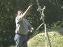 Roddney, KD7SXZ, aims the Super Slingshot, to drop a line into the tall fir trees.