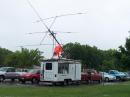 More of the "tough-job-but-somebody-has-to-do-it" category, K5WAR is  seen here pushing up the crank-up tower that will support the HF yagi, a two-meter vertical, and an 80-meter inverted-dipole as part of Station #1 in the HOTARC trailer. (Ok...maybe he has some help with that mast... :-)