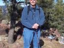 Bob K0NR standing near the summit of Mt Herman with all the VHF radio gear in a backpack.