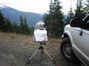 K7MDL/R 10GHz setup with towel to keep the light rain and cold wind off.  Pointed south at N7EPD and KB7DQH/R on Poch's Peak in CN96 (about 130km).   This is Sunday afternoon on Green Mountain in CN98 at 2950ft.  The snow topped mountain to the left is Mt. Pilchuck with the often visited "bench" area visible just to the immediate left of the dish.   Everett is about 90deg to the right from this angle.   The black box on the back is velcro'd in place and is a 15.36MHz TCXO connected into the directional coupler to act as a reasonably accurate marker generator at 10368.088MHz.  I added a crystal oven to the brick PLO last week, and after a short warm up I found the stations quickly within 3 KHz of where I expected. W7NBH in eastern Washington CN96 came in strong over the Cascade mountain range on this angle on 6M through 1296, working the bounce off Mt. Rainer in CN96.  It was mostly dry except when we wanted to work 10GHz!