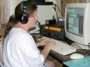 Rebecca's mother Barb KGØUT operating the HF phone station.  YL mother/daughter team made major impact on QSO totals.