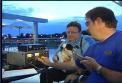 Dave Harmon, N0TPQ (holding Bandit) and Todd Butler, N0NCL at the microphone at sunset on the southern shore of Gray's Lake Park, in Des Moines, Iowa.