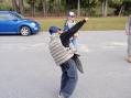 One of the cub scouts struggles to don 50 pounds of body armor prior to running a foot race with his pals.