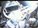 Sergei Volkov, RU3DIS, takes the protective wrappings off ARISSat-1 shortly after today's spacewalk began. [Screengrab from NASA TV]