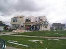 A family surveys their home, destroyed by a tornado in Northwestern Ohio. [Tony Everhardt, N8WAC, Photo] 