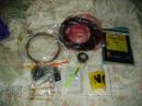 The contents of the Go-kit. Along with the coax and antenna, there is a roll of tape, nylon cord, a compass a utility knife, a pencil, note pad, yellow warning tape, a small measuring tape and even an old <em>ARRL Antenna Book</em>. Note that everything is in plastic bags.