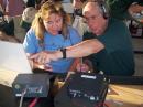 Cynthia Kirchner, KJ4DYI, listens as Jim Stafford, W4QO, explains HF operations at NFARL's GOTA station.