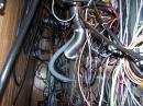 Yeah I know, it used to be called "wireless". Here is a shot from behind the racks in the microwave shack. The large hoses are air hoses for remote blowers to feed cooling air to the 222 and 432 PAs (8877 and 8938 triodes) There are also large 4" air ducts to remove the heated exhaust air from the shack. With seven guys sitting in the small room, and two kilowatt amps pumping out rf, the temperature would quickly soar if we did not do something about the heat removal. 