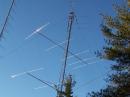 The  3 X 5 element home brew 10 meter yagis perched on a 70 ft Rohn 45 tower.  There is a homebrew switching box way up on top to select various combinations of the ten meter yagis. This picture was taken before I installed TIC Ring rotors on the bottom two antennas.  The other tower in the background on the left, is for 144 MHz. There are 20 yagis on that tower, all for 144 MHz.