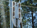 This is the center element of my "Emcom DIpole". It is a modular version of a fan dipole purpose-built for multi-band field use. The four sets of posts allow you to attach wire elements for any band or sub-band that you like. With a rope and pulley system at the top of the mast you can lower the center insulator, change out the elements (no tools required), and then re-raise the center in about two minutes. Near-instant band changes!