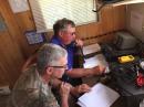 Old ham Rich, W0TF, helps new ham Gary, KD0NVV, learnt he ropes of Field Day operating.	