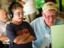 Joseph (10) makes a SSB contact with coach Ed, K1NUH. (Photo: Dan Ewart, WG4F)