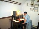 Pete KK7QW operates the Globescout rig on 80 meters with KG6EIP.  The parallel feed line can be seen entering the museum shack above the knife switch and traveling along the sloped ceiling. The stations took turns using the same antenna via the ceiling feedline.