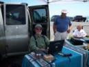 Michael, N7BBQ, beams from the helm of the Information station. Bob, KF7APN, one of our newer hams and Rich, W7UDH, look on.