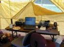 The operating position at W1FYM.  Battery power is from the deep-cycle marine battery at the left of the table.  Bouncy air-cushioned office chairs made operation reasonably comfortable.  The two most important items are the coffee cups, followed by the Icom 751 running at 5 watts and the wire tuner.  The A.C. extension cord is for the coffee pot and a BIG cooling fan.  The weather was blazing hot, humid, around 95 degrees in Portland, Connecticut.