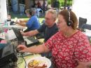 Mike, KD7IBE, logs as Cleo, KC7TTM, operates 20 phone with Maria, KE7DSK, in the background on the GOTA station.