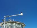 Marc Savignac (ham in training) in boom truck, raising CW beam to Steve, VE3CWJ on top of silo. With all metal roofs, there was no problem with ground planes!