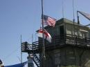 Raising the 80 meter dipole, along with the American and Royal Navy flags.  This building is used for emergency services repeaters.